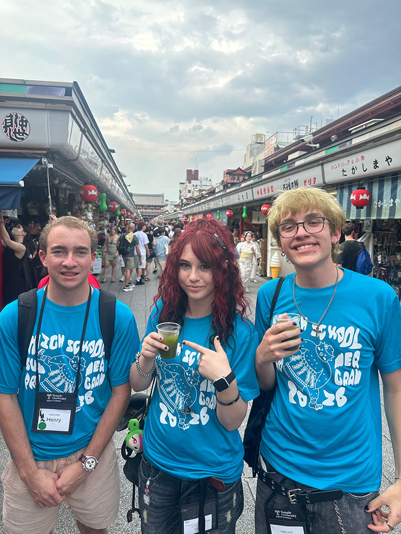 Three students wearing matching T-shirts at Nakamise shopping street in Asakusa.