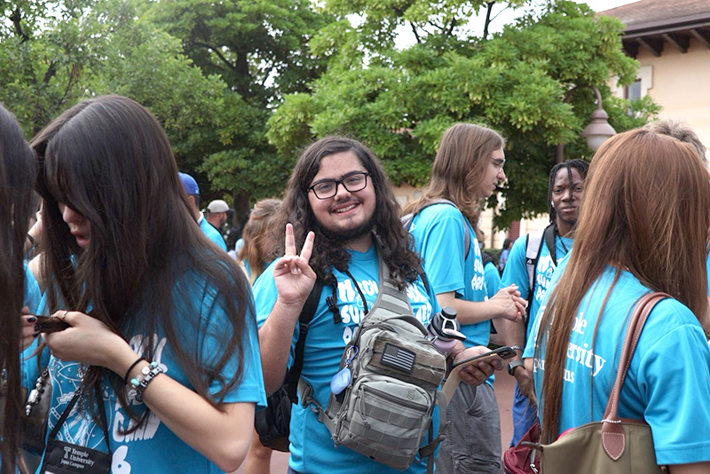 A group of students wearing matching T-shirts at an outdoor event.